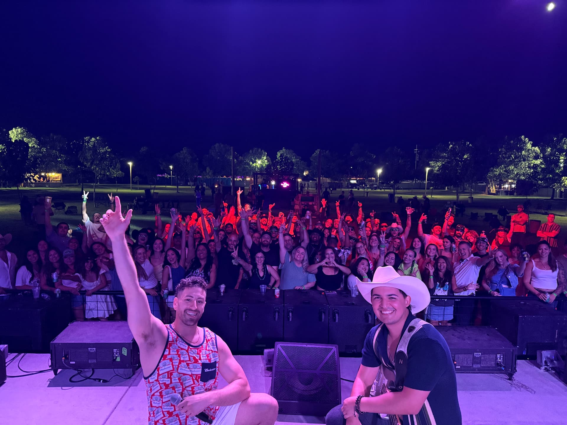 DJ Jordan Miller and guitarist Kristian Cruz performing together onstage with the crowd behind them at ApCal Rock N' Ranch in Fresno, California.