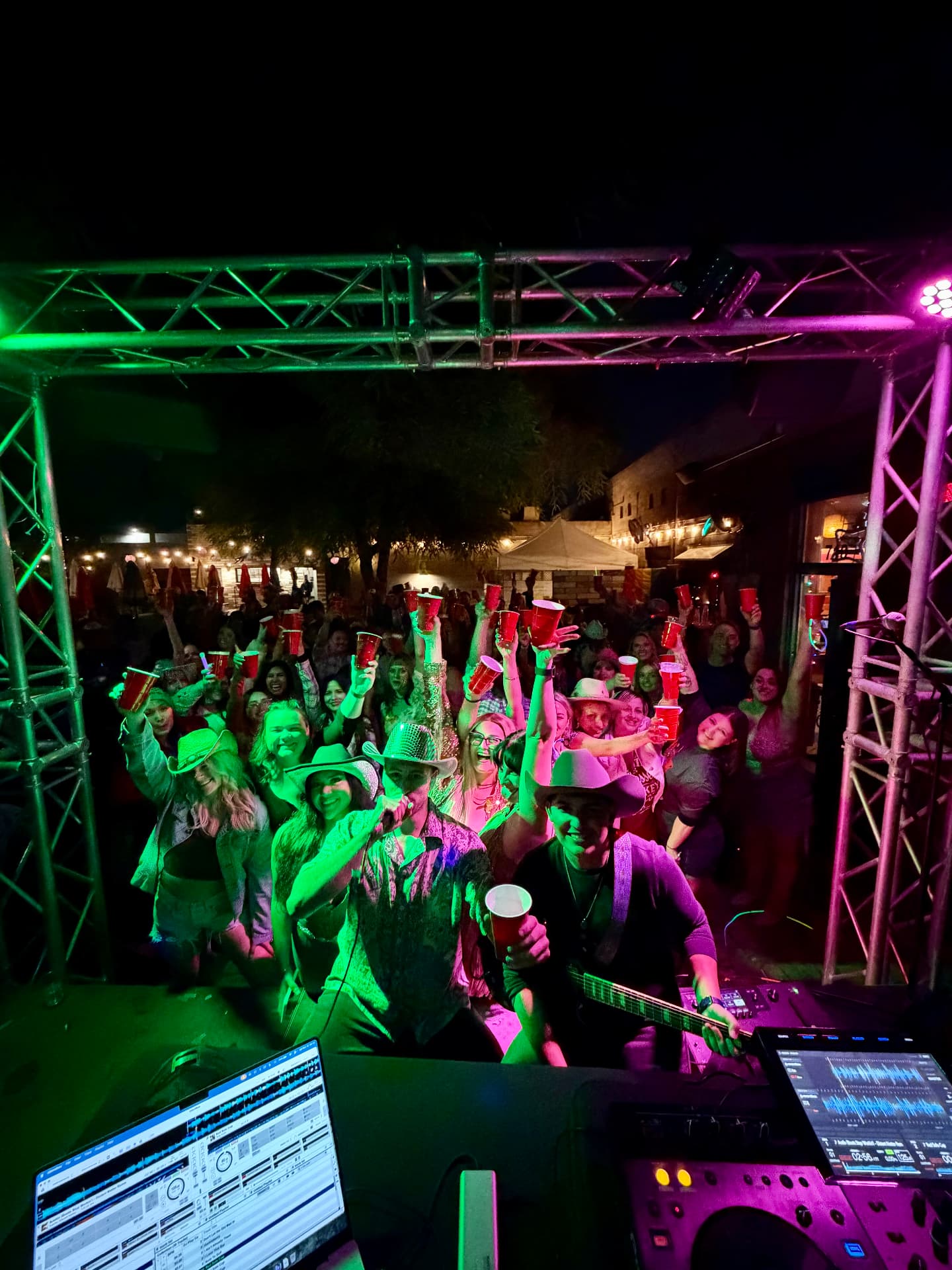 Jordan Miller at the decks and Kristian Cruz on live electric guitar with the Thunderbird Lounge crowd raising cups in Phoenix, Arizona.